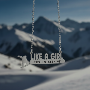 Necklace with 'Like a Girl, Try to Keep Up' pendant against a mountainous background