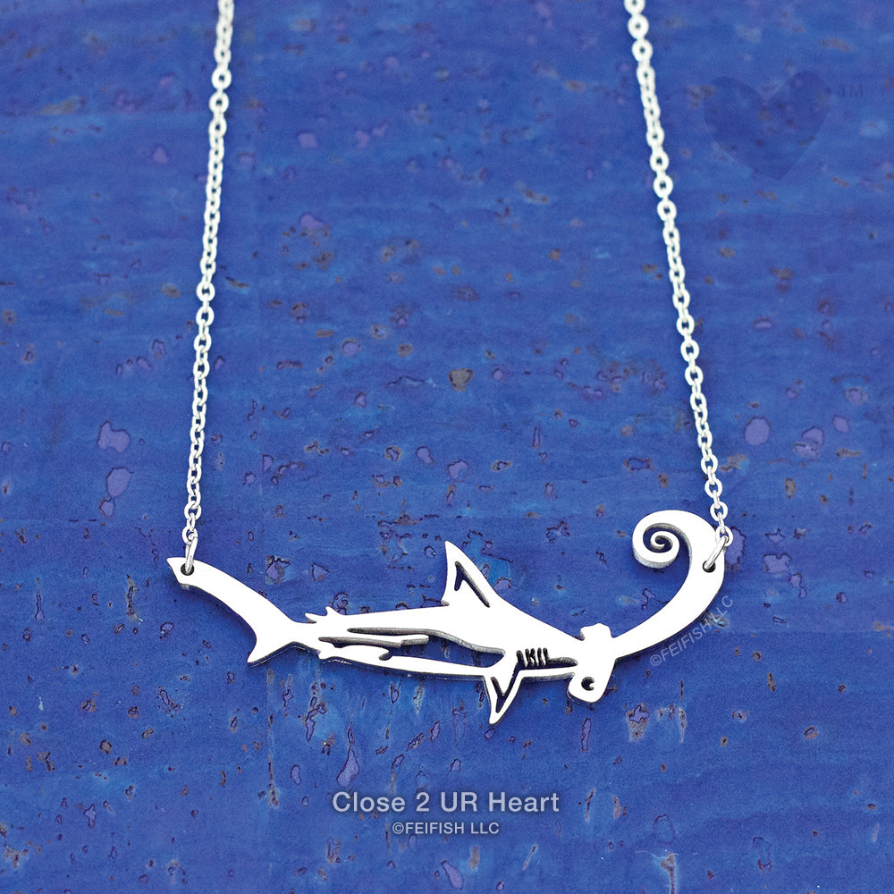 A Hammerhead Shark is naturally designed with a cephalofoil head which helps with maneuverability, binocular vision, scent detection and electromagnetic field energy.

Our original stainless steel pendant is 2-inches wide, with a 16+2-inch stainless steel necklace and clasp. Stainless Steel jewelry is versatile, durable, and nearly maintenance-free. ©FEIFISH LLC dba Close 2 UR Heart