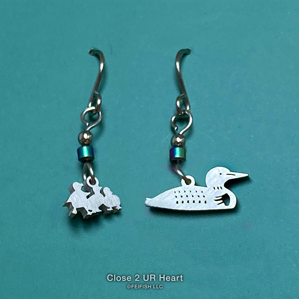 A pair of stainless steel earrings with an adult loon and loon chicks, featuring stainless steel ear wires and hematite beads.